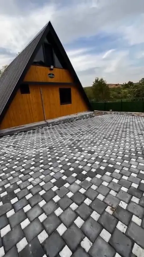 Siyah eğimli çatısı ve ahşap cephesiyle A tipi bungalovun dış görünümü