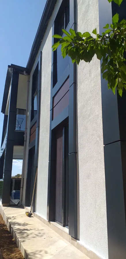 Açık renk ve koyu cephe yüzeylerinin bir arada kullanıldığı yapı